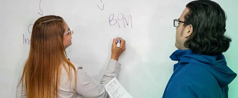 Imagen de una capacitación BPM práctica en Insega, con un consultor explicando conceptos clave en una pizarra blanca. Capacitación especializada para empresas.